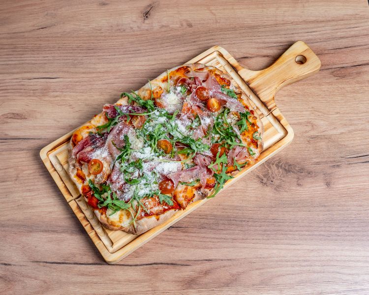 Prosciutto and Arugula thin crust pizza with Italian prosciutto